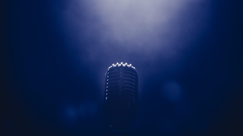 A silver microphone on a dark blue background