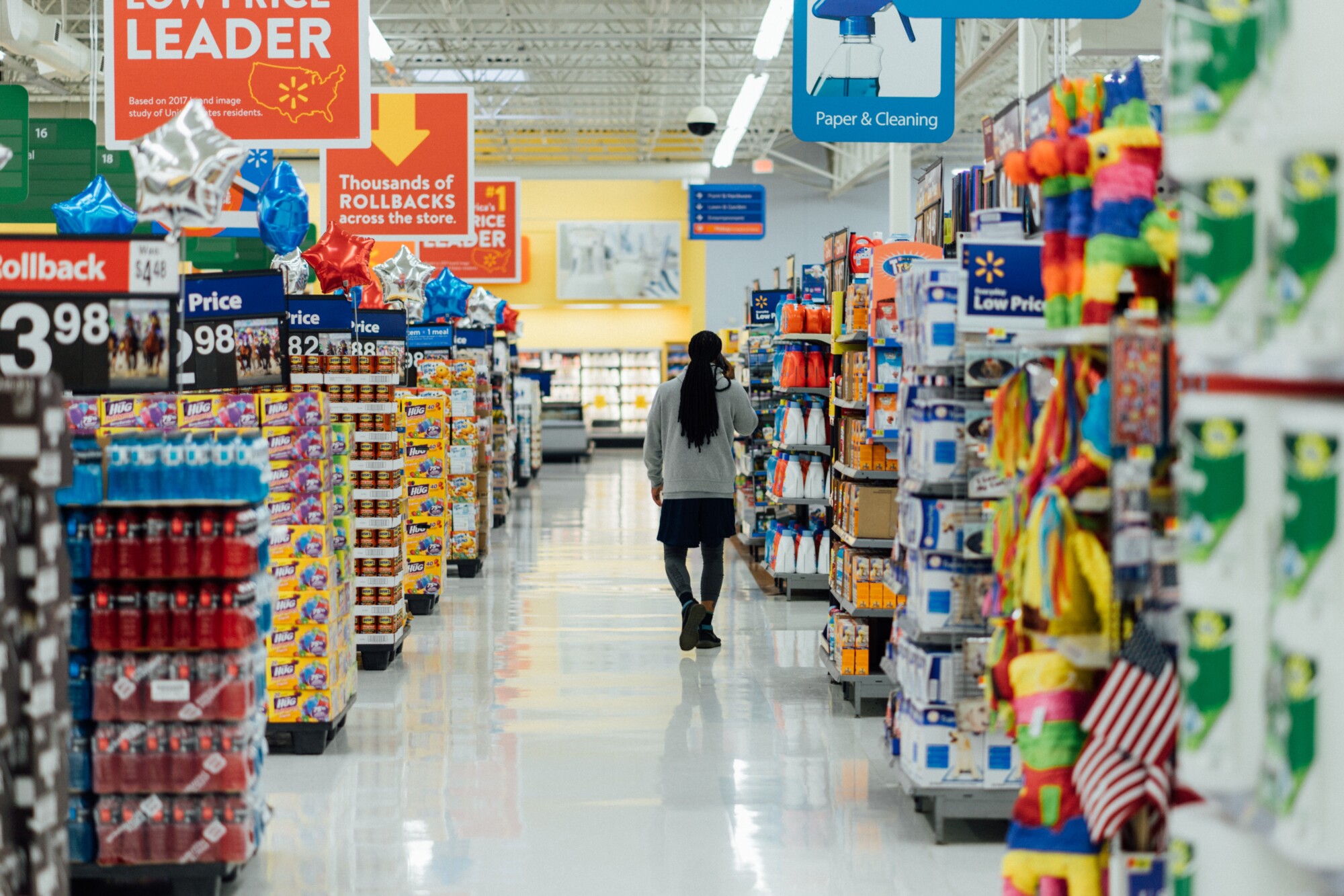 Photograph of a person walking down a supermarket aisle